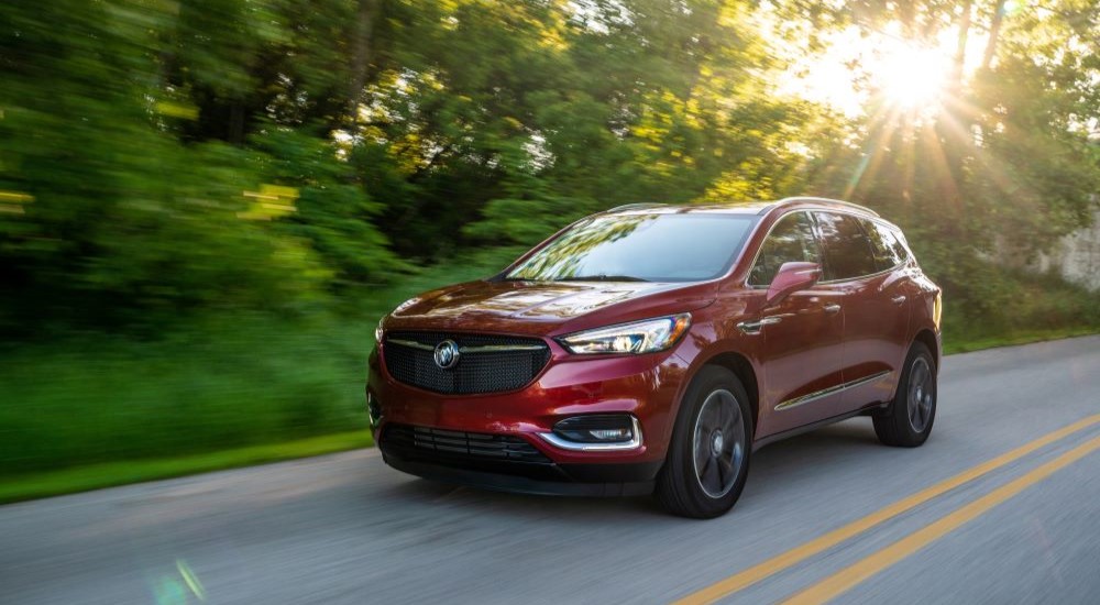 A red 2020 Buick Enclave Sport Touring is shown driving to a used Buick dealer.