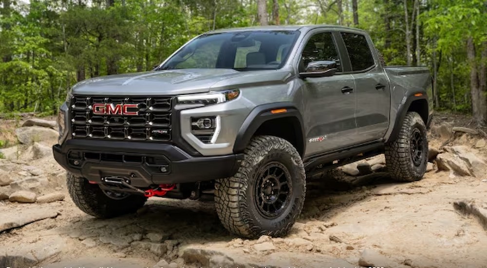 A grey 2024 GMC Canyon AT4x is off-roading on a rocky trail after leaving a GMC dealer near Minneapolis.