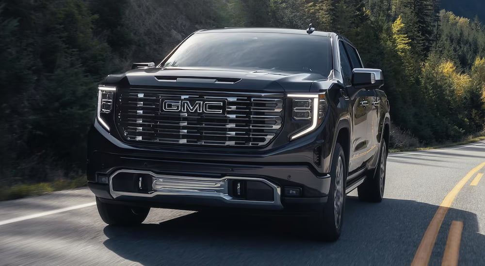A black 2025 GMC Sierra 1500 Denali Ultimate driving from a GMC dealer near Le Sueur.