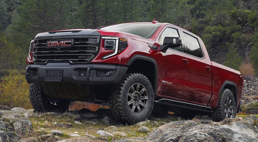 Low angle view of a red 2025 GMC Sierra 1500 parked on a boulder.