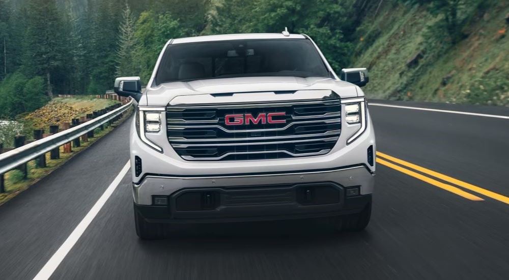 A white 2025 GMC Sierra 1500 driving to a GMC dealer near Owatonna.