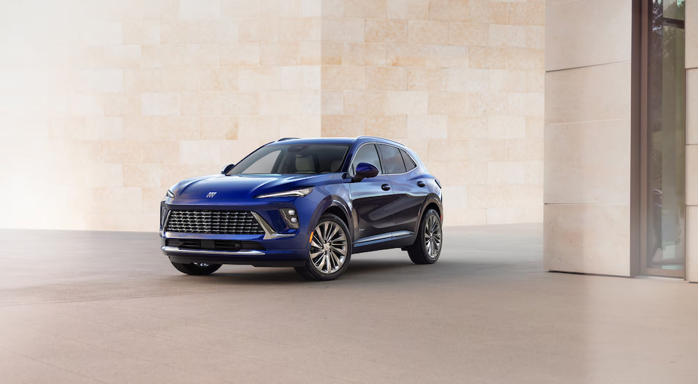 Blue 2025 Buick Envision for sale parked in front of a wall.