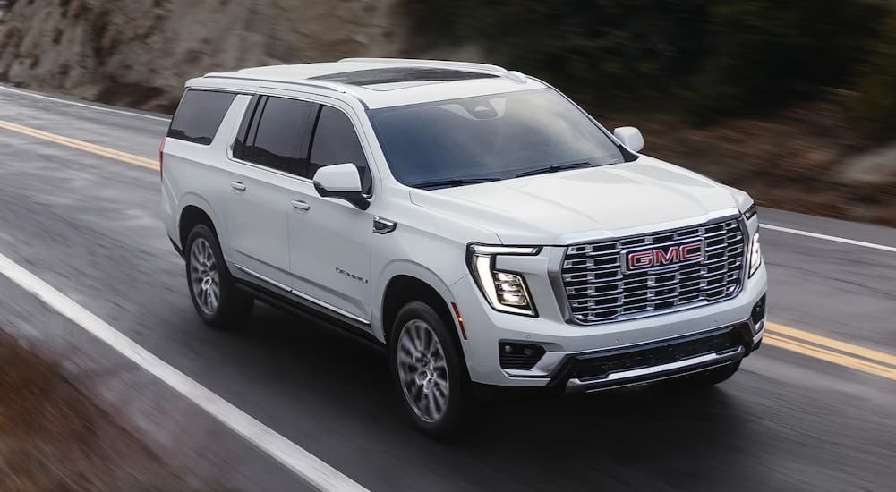 A white 2026 GMC Yukon driving to view a GMC Yukon for sale.