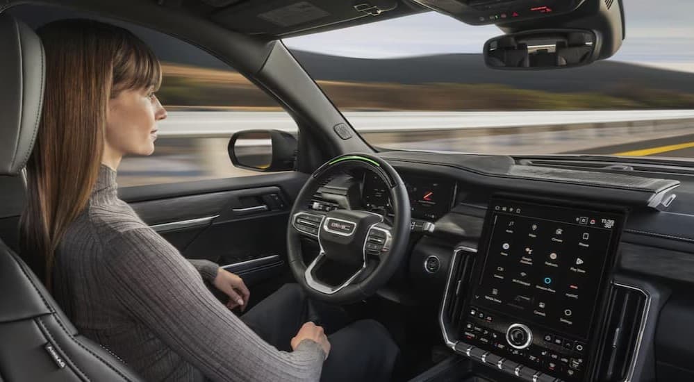 A person driving in a 2026 GMC Acadia.