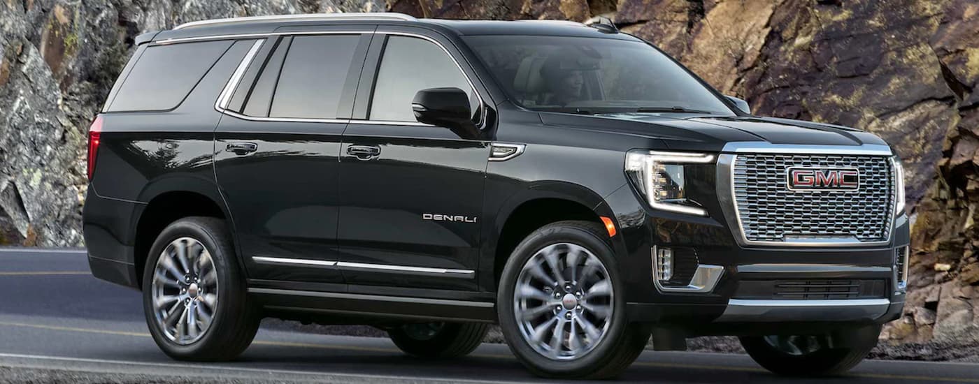 Black 2023 GMC Yukon Denali driving down the road