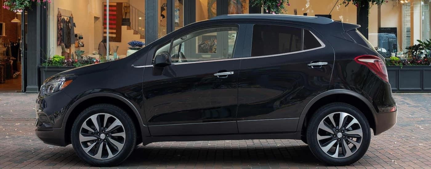 A grey 2022 Buick Encore is shown from the side parked on the side of a city street.