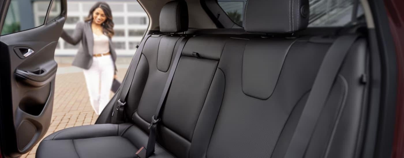 A woman is getting into the back seat of a 2024 Buick Encore GX.