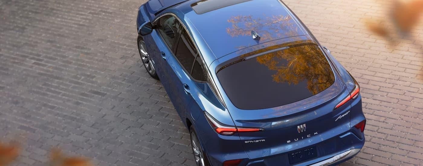 A blue 2024 Buick Envista Avenir is parked on a stone driveway.