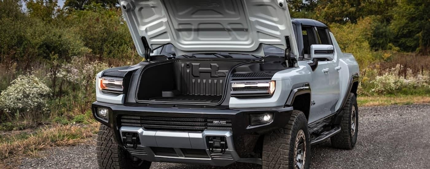 A silver 2022 GMC Hummer EV is shown with the frunk open.