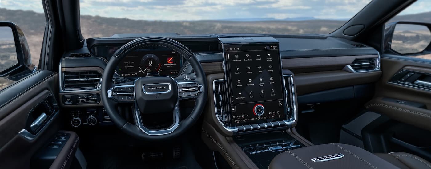 Black wheel and dashboard in the interior of a 2026 GMC Yukon XL.