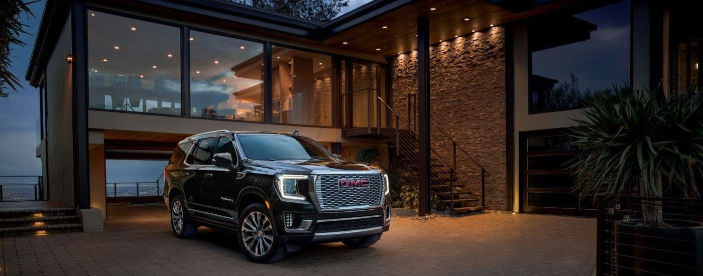 A black 2024 GMC Yukon Denali is parked in a driveway.