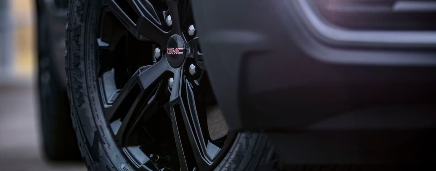 A close up of the rim and tire on a black 2022 GMC Terrain AT4 at a SUV dealer in Mankato.