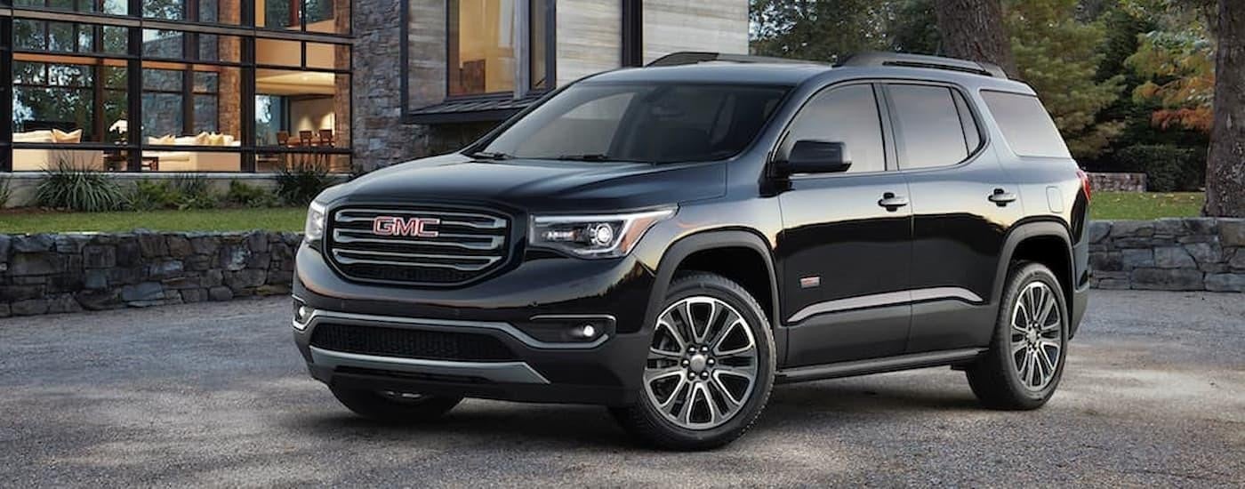 A black 2017 GMC Acadia is shown parked on a driveway.